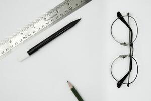 espacio en blanco para letras. Copie el espacio para mostrar el proyecto de escritura a mano. un escritorio vacío con un fondo blanco desde el punto de vista superior. papelería rodea el espacio. foto