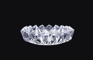 luxurious crystal ashtray isolated on black background. a single transparent glass container for minimalist home decoration. photo