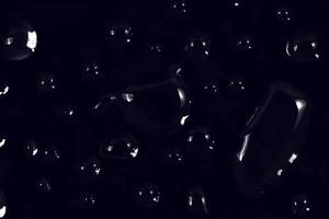 gotas de agua sobre fondo negro. Gotas de agua de rocío abstracto en el vidrio de una ventana para un efecto de superposición de fotos o para dar un efecto fresco en la maqueta de bebidas. tiro macro de la gota de agua detallada.
