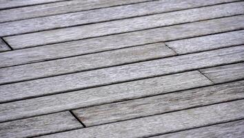 the wooden plank texture of the boardwalk in diagonal horizontal view. weathered board in faded brown color. the shabby surface for nature background texture collection. photo