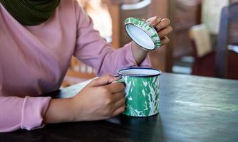 a girl holds a tasty traditional beverage. a kind of enjoying leisure time by drinking a tasty and relaxing beverage. photo