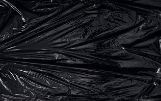 una envoltura de plástico transparente sobre fondo negro. textura realista de envoltura de plástico para superposición y efecto. patrón de plástico arrugado para un diseño creativo y decorativo. foto