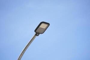 a lamp street with a lampshade hanging on the electricity cable. a lamp to illuminate the road at night. photo