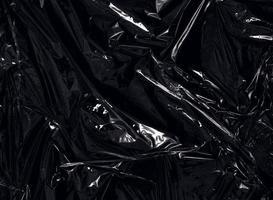 una envoltura de plástico transparente sobre fondo negro. textura realista de envoltura de plástico para superposición y efecto. patrón de plástico arrugado para un diseño creativo y decorativo. foto