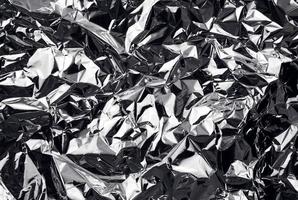 crumpled aluminum foil background. wrinkled shiny silver foil for decoration. creative design element in shabby shape. abstract texture surface from wrapping paper. photo