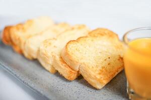 some toasted bread served on a plate with a cup of orange juice isolated on white. a perfect menu for western breakfast. photo