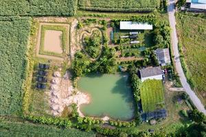 Patrón de vista aérea de agricultura mixta con casa, plantación y estanque en tierras de cultivo foto