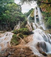 Erawan waterfall 7th floor with water flowing in tropical rainforest at national park photo