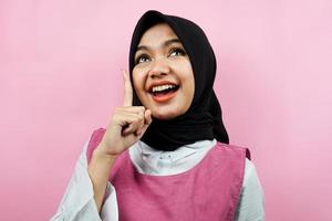 Closeup of beautiful young Muslim woman pointing up isolated photo