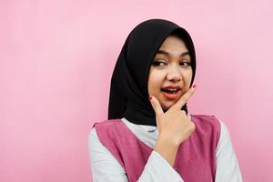 Primer plano de una joven y bella mujer musulmana mirando el espacio vacío, presentando algo, aislado