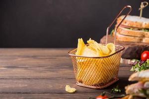 Crispy potato chips in copper basket photo