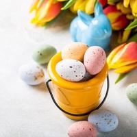 Composición de pascua con huevos de codorniz y tulipanes. foto