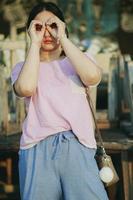 teenager standing outdoor acting as looking through binocular lens photo