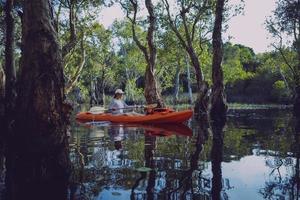 woman sailing sea kayak  at mangrove forest canal photo