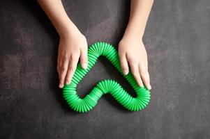 pop tube poptube kid niños juguete antiestrés manos sosteniendo jugar foto