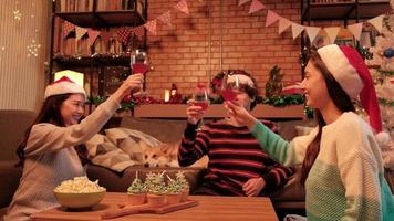 le bonheur que la famille et les amis célèbrent, levant des verres et un sourire joyeux avec des boissons, des cupcakes et du pop-corn dans le salon de la maison, décoré pour la fête du festival de noël et le jour de l'an. video