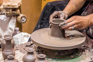 A potter is sculpting a pot. photo