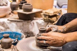 A potter is sculpting a pot.