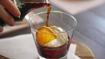 pouring iced cold brew coffee on ice ball in glass video