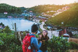 Couple Asian traveling together on mountain in Ban Rak Thai village countryside. Travel, camping in the winter, Outdoor relaxation, Romantic couples. photo