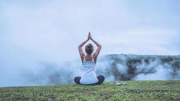 las mujeres asiáticas se relajan en las vacaciones. jugar si yoga, bosques naturales, montañas y niebla. foto