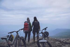 Asian lover women and men Travel Nature. Travel relax ride a bike Wilderness in the wild. Standing on a rocky cliff. Thailand photo