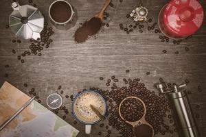 Granos de café marrón y una taza de café caliente colocados sobre una mesa de madera. concepto de viaje con mapa. tiempo para relajarse con una taza de buen café. espacio de copia de vista superior para su texto. foto