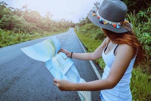 Asian women travel relax in the holiday. Take a look at the map on a rural road in the middle of nature. Thailand photo