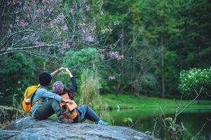 Lovers travel to watch the cherry trees of Asian couples. Happy with honeymoon travel,valentines. photo