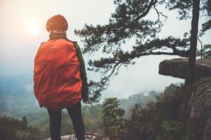 las mujeres asiáticas viajan por la naturaleza. viajar relajarse. Levántate paisajes en el acantilado. al amanecer que tiene guarda niebla. tailandia foto