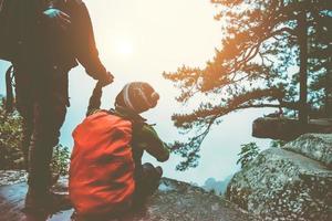 Asian lover women and men travel nature. Travel relax. landscapes on the cliff.  At sunrise which has fog guard. Thailand photo