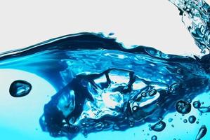 Resumen de salpicaduras de onda de agua transparente azul con burbujas de agua en blanco. foto