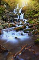 hermosa cascada panorámica hermosa profunda y negra roca verde bosque natural en la naturaleza. foto
