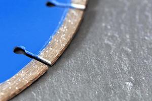 Segment of a diamond cutting disc on a background of gray concrete. photo