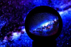 Stars of the Milky Way galaxy are reflected in a crystal ball photo