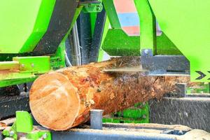 A large log is cut at a modern sawmill, woodworking industry. photo