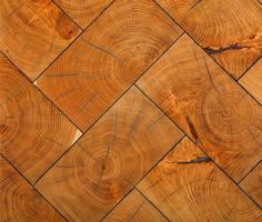 The rectangular planks of the transverse saw cuts of the trees are neatly lined with herringbone pattern.