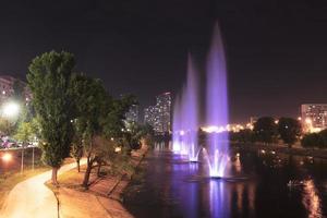 Beautiful, bright and high fountains on the Rusanovskiy channel in the night Kyiv photo