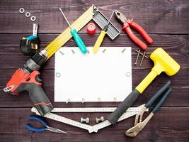 The tool building on the wooden background around the white sheet of paper photo