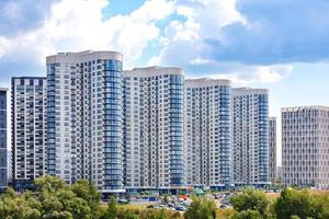 las fachadas de los nuevos rascacielos residenciales contra un cielo nublado azul. foto