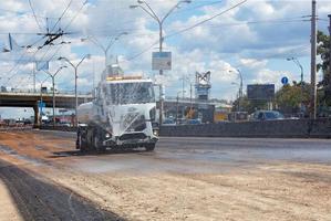 A watering machine waters the road on a hot sunny day. photo