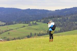 A photographer photographs the landscape of the Carpathian slopes. photo