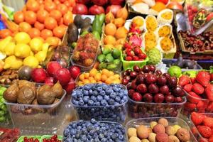 arándanos, frutos de serpiente, cerezas, lima, granadas, fresas, ciruelas, limón, aguacates, mangos están en el mercado para la venta.