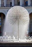 A beautiful city fountain in the shape of a huge dandelion refreshes passers-by against the background of the arched-column facade of the Kyiv City Conservatory. photo