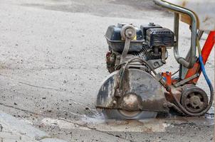 The petrol cutter is in operation and cuts the asphalt with a diamond cutting disc. photo