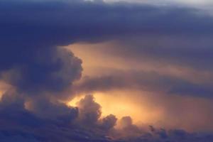 Brilliant orange sunset and sunrise beautiful over dark blue clouds with bright orange sun on a cool spring morning. photo