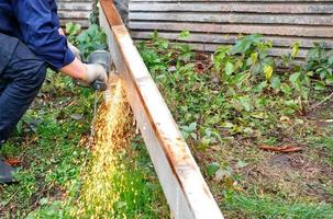 A worker cuts a metal structure using an angle grinder. photo