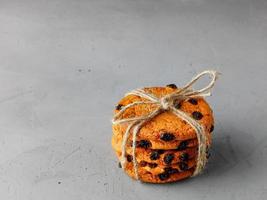 Homemade oatmeal cookies are tied with string on a gray concrete surface. Copy space. photo