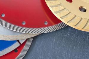 Diamond discs for concrete, reinforced concrete, granite and stone on the background of a slab of gray sandstone stone photo