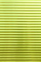 The background and texture of the metal blinds are light green in color.
